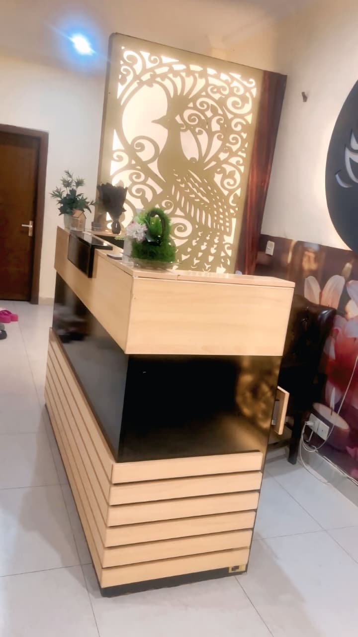 Spa reception desk with backlit gold peacock screen at our Bahria Town Phase 7 spa