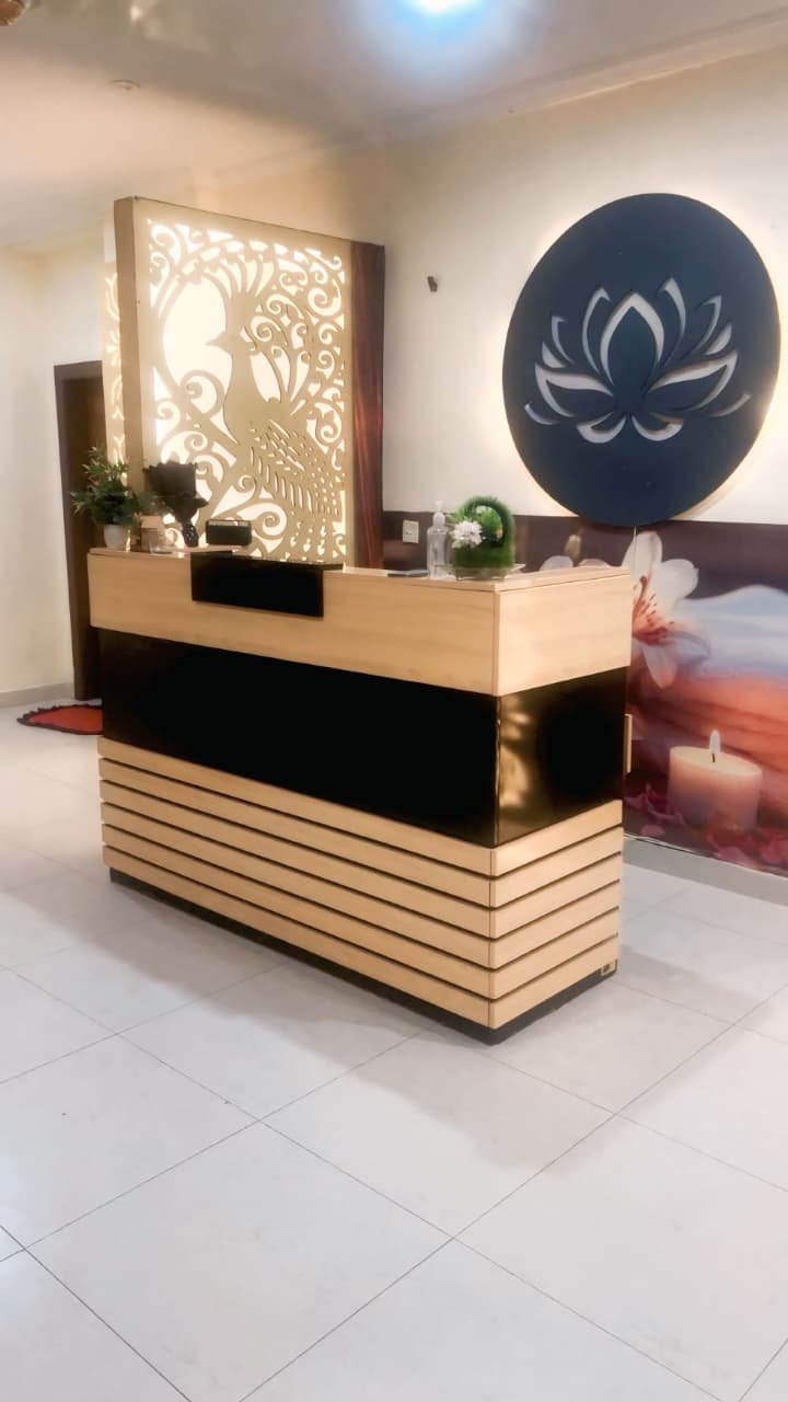 Spa reception desk with lotus emblem and gold peacock panel